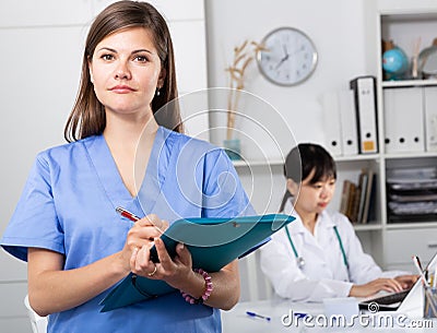 Doctor assistant standing in medical office noting prescriptions Stock Photo