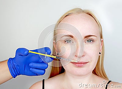 The doctor beautician conducts contour plastic lips: an injection into the lips, lip augmentation. Hyaluronic Acid Injection Stock Photo