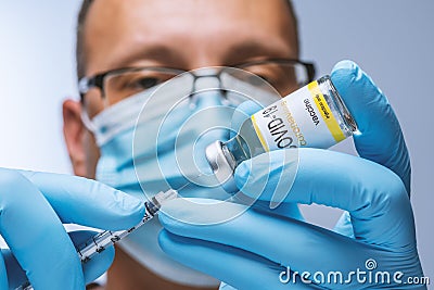 Doctor in blue latex gloves fill in syringe with vaccine from glass vial. Stock Photo