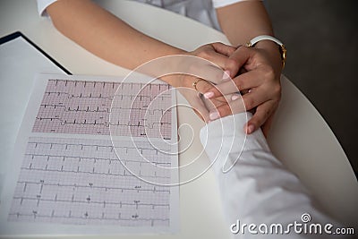 Doctor cardiologist holds a person`s hand, makes a diagnosis, calms the patient. Stock Photo