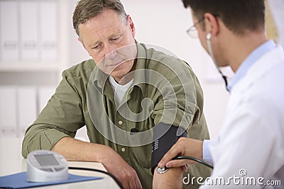 Doctor checking blood pressure Stock Photo