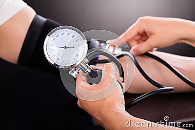 Doctor Checking Blood Pressure Of Patient Stock Photo