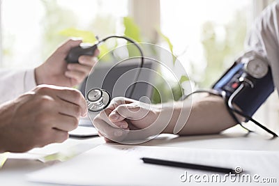 Doctor measuring blood pressure of patient Stock Photo