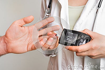 Doctor checking blood sugar level with glucometer Stock Photo