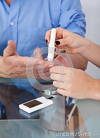 Doctor checking glucose level in diabetic patient Stock Photo