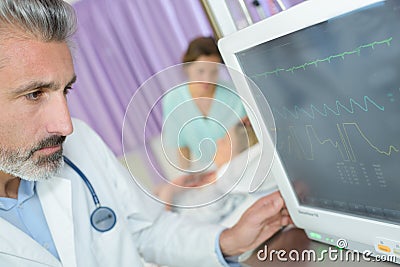 Doctor checking heart rate monitor Stock Photo