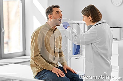 doctor checking male patient's throat at hospital Stock Photo