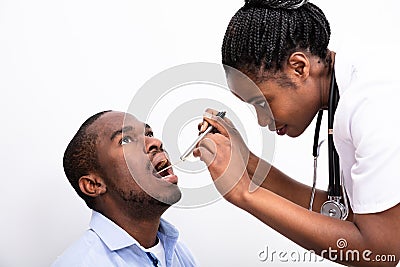 Doctor Checking Man`s Sore Throat Stock Photo