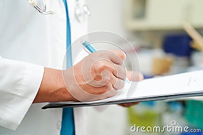 Doctor checking and note diagnosis medicine in clipboard of patients in hospital Stock Photo