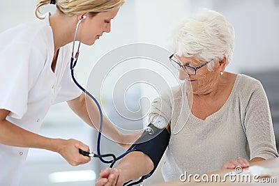 Doctor checking on patient's blood pressure Stock Photo