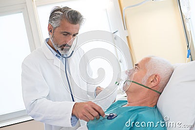 Doctor checking on senior patient heart rate Stock Photo