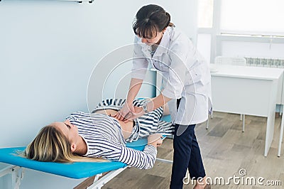Doctor checking the stomach of one of her patients Stock Photo
