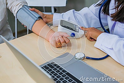 Doctor checking woman patient arterial blood pressure. Health c Stock Photo