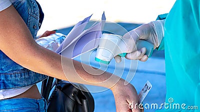 The doctor checks the girl`s temperature with an infrared non-contact thermometer Stock Photo