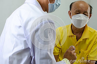 Doctor checks the heartbeat of an elderly man Stock Photo