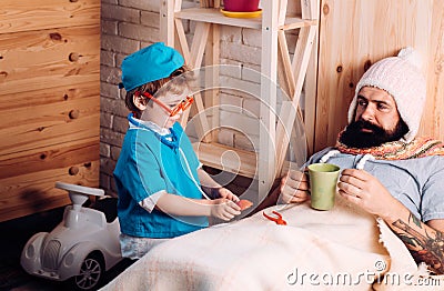 Doctor child in glasses with stethoscope examine father at home Doctor boy in doctor uniform treat patient, game and Stock Photo