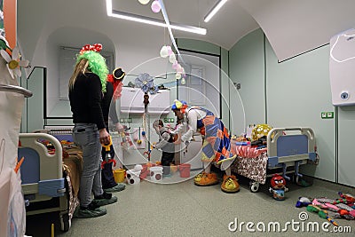 Doctor in clown costume examines the child Editorial Stock Photo