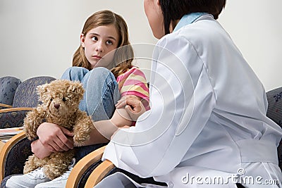 Doctor comforting nervous girl Stock Photo