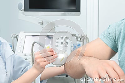 Doctor conducting ultrasound examination of patient`s elbow Stock Photo