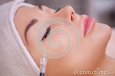 The doctor cosmetologist makes the Botulinotoxin injection procedure for tightening and smoothing wrinkles on the face Stock Photo