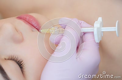 The doctor cosmetologist makes the Botulinum Toxin injection procedure for tightening and smoothing wrinkles Stock Photo