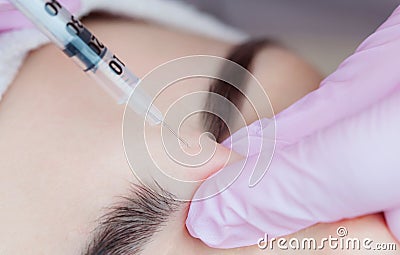 The doctor cosmetologist makes the Botulinum Toxin injection procedure Stock Photo