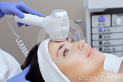 The doctor-cosmetologist makes the Cryotherapy procedure of the facial skin of a beautiful, young woman in a beauty salon. Stock Photo