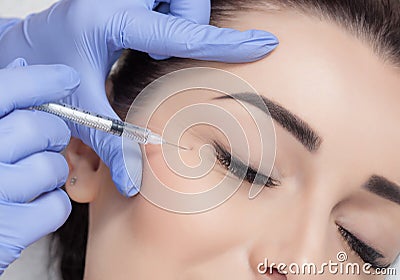 The doctor cosmetologist makes the Rejuvenating facial injections procedure for tightening and smoothing wrinkles on the face Stock Photo