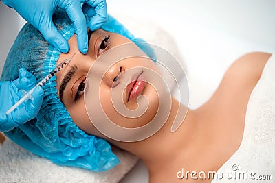 The doctor cosmetologist makes the Rejuvenating facial injections procedure for tightening and smoothing wrinkles on the Stock Photo