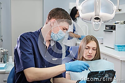 Doctor dentist man shows to patient girl x-ray Stock Photo