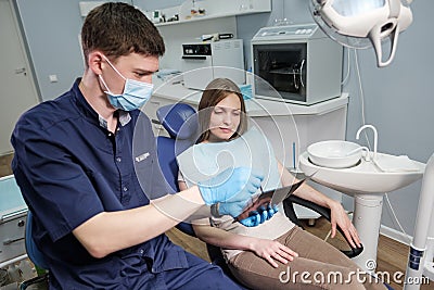 Doctor dentist man shows to patient girl x-ray Stock Photo