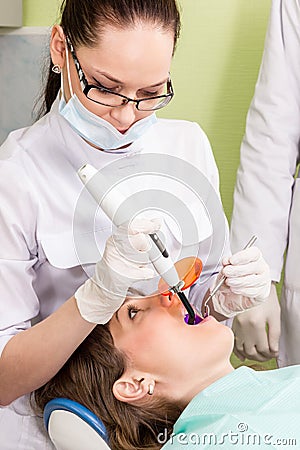 Doctor dentist puts filling Stock Photo