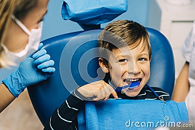 Doctor dentist teaching a child to brush teeth. Stock Photo