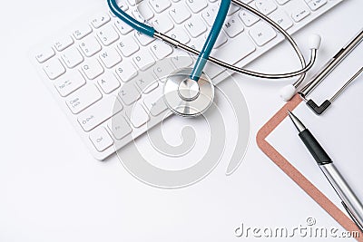 Doctor diagnoses concept - stethoscope on computer keyboard with medical record case and pen on white working table. Top view, Stock Photo