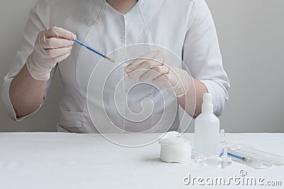 The doctor dials the drug or vaccination into the syringe. In front of the doctor, everything necessary for the injection is laid Stock Photo