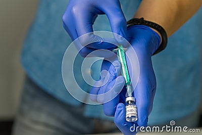 doctor dials the vaccine into a syringe. a nurse with a vaccine and a syringe in her hands Stock Photo