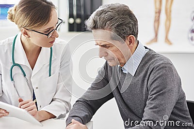 Doctor with digital tablet discusses the results of the senior Stock Photo