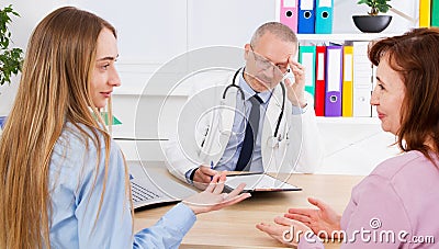 Doctor discusses something with his patients,medical insurance Stock Photo