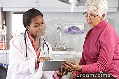 Doctor Discussing Records With Senior Female Patient Stock Photo