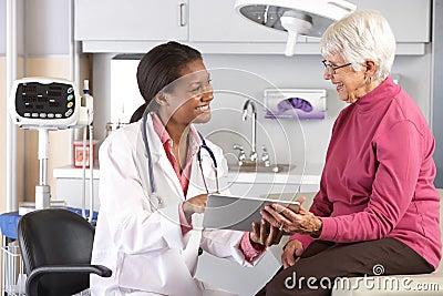 Doctor Discussing Records With Senior Female Patient Stock Photo