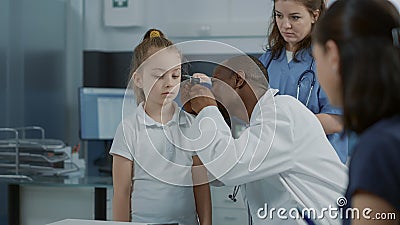 Doctor doing otology examination with otoscope to see ear infection Stock Photo
