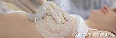 Doctor doing ultrasound scan of breast to young woman in clinic closeup Stock Photo