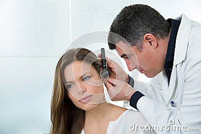 Doctor ENT checking ear with otoscope to woman patient Stock Photo