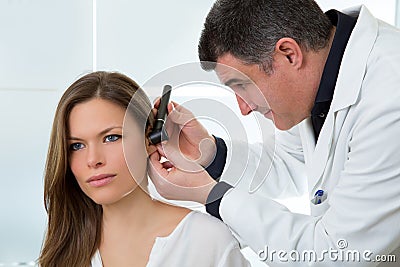 Doctor ENT checking ear with otoscope to woman patient Stock Photo