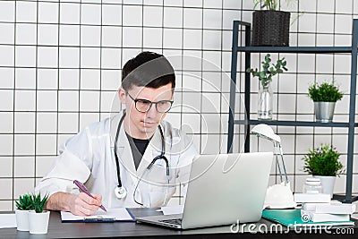 Doctor entering patient notes on a laptop in surgery Stock Photo