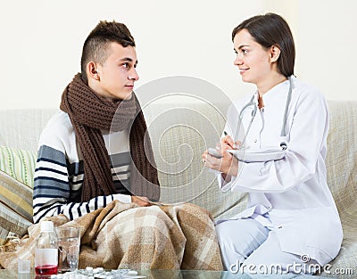 Doctor examinating teen boy with quinsy at home Stock Photo