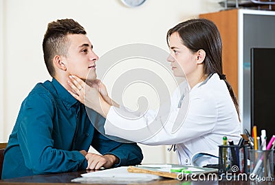 Doctor examinating teen boy with quinsy at office Stock Photo