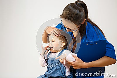 The doctor examines the child while he nibbles at the stethoscope Stock Photo