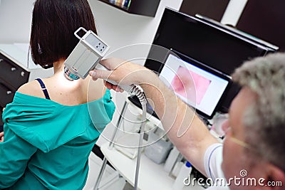 The doctor examines neoplasms or moles on the patient`s skin Stock Photo