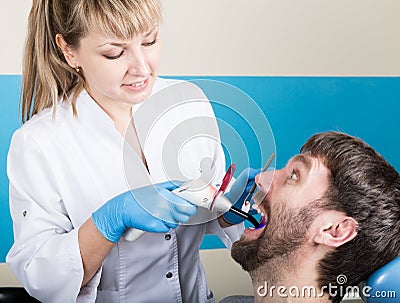 Doctor examines the oral cavity on tooth decay. Caries protection. Tooth decay treatment. Dentist working with dental Stock Photo